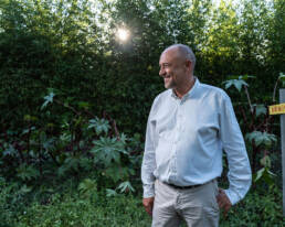 Carlos Mendes Gonçalves num campo com vegetação e sol ao fundo.